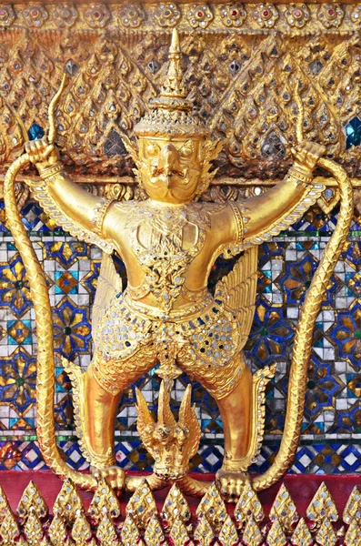 Золотая статуя на стене в большом дворце — стоковое фото