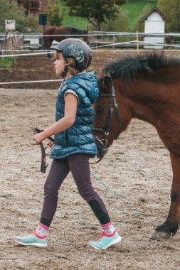 Avusturya 'da bir çiftlikte güzel atlar. Küçük kız binicilik sporlarına gidiyor. Çocuk ata biniyor..
