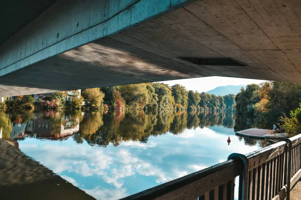 Avusturya 'nın sonbahar şehrinde nehrin üzerinde güzel bir köprü. Nehrin karşısındaki dağlarda köprü.