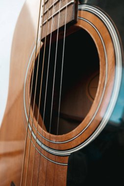 Kahverengi akustik gitar ve yakın çekim telleri.