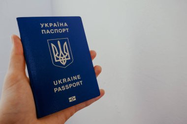 Beyaz arka planda bir el Ukrayna vatandaşının pasaportu.