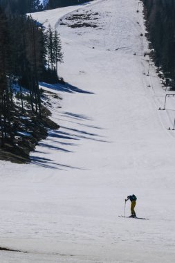 Avusturya 'nın karlı dağlarında kayakçı. Dağların arka planında bir adamın silueti. Alplerde kayak merkezi.