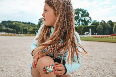 Küçük bir kız çocuğu düştü ve bacağını incitti. Dizindeki yara bantla kapatılmış..