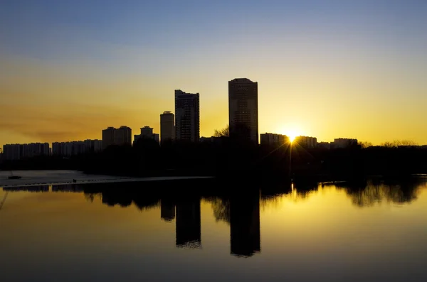 Sonnenuntergang in der Stadt, Spiegelung im glatten Wasser — Stockfoto
