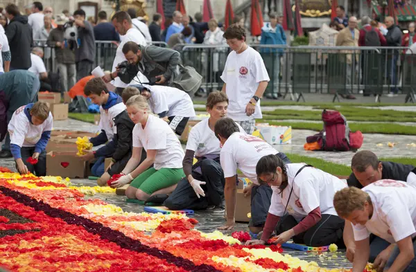 Άνθρωποι δημιουργούν λουλούδι χαλί στην πλατεία Γκραν Πλας — Φωτογραφία Αρχείου