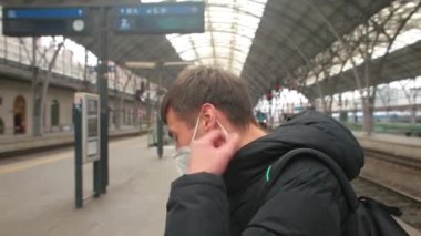 Adam maskeyi yüzünden çıkarır. Nakil için beklerken biraz temiz hava..