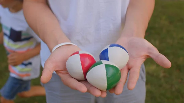 Balls in the hands are prop used by jugglers. This three-pack of juggling balls — Stock Photo, Image