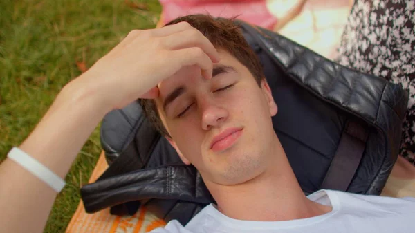 Человек отдыхает во время перерыва в парке, массаж лба. Напряжение усталости. — стоковое фото