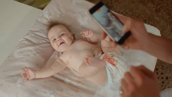 신생아와 부모가 전화기를 들고 있다. 새로운 부모를 위한 최고의 아기 앱 — 스톡 사진