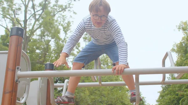 Down syndrome adolescent grimpe obstacle terrain de jeu trains muscles endurance — Photo