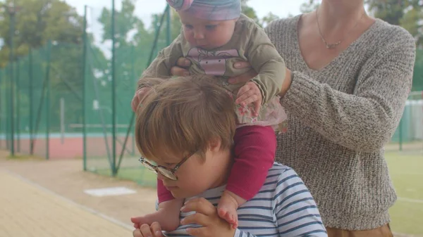 Toddler girl sits shoulders down syndrome teenager Tactile sensations — Stock Photo, Image