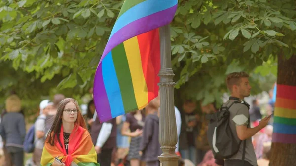 Menina envolta em uma bandeira LGBT ocorre em um festival ao longo do caminho — Fotografia de Stock