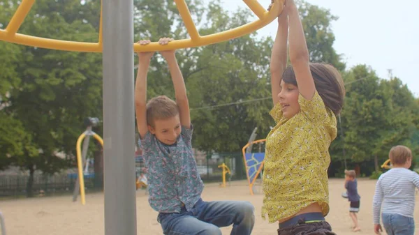 Boys spinning on the playground. Developing vestibular system. — Stock Photo, Image