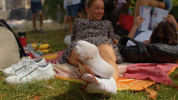 Πόδια σε άσπρες κάλτσες μιας νεαρής γυναίκας που ξεκουράζεται στο πάρκο. Λατρεία ποδιών ως φετίχ. — Φωτογραφία Αρχείου