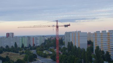 Akşam kent manzarasına karşı bir vinç. Bir yerleşim alanının geliştirilmesi.