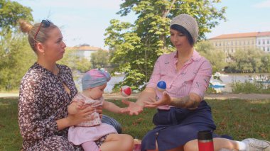 Anne kızına ilgiyi kontrol etmeyi öğretiyor. Topları atıyor, koordinasyon sağlıyor.. 