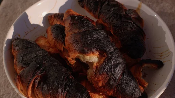 Croissant ars în farfurie. Bucătarul a făcut o eroare de temperatură a timpului de gătit. — Fotografie, imagine de stoc