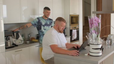 Mutfakta çalışan iki eşcinsel adam sakal bilgisayar masası partneri kullanıyor. 