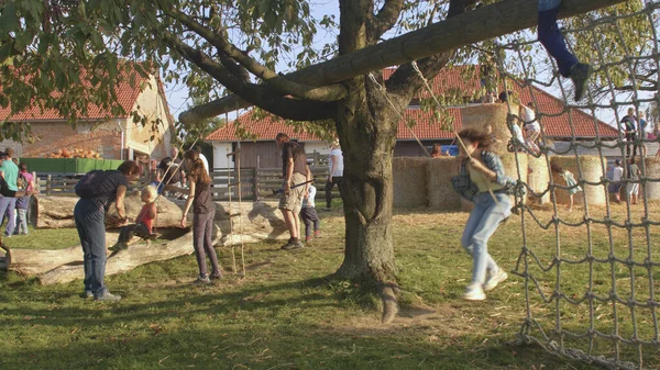 Week-end activités avec les enfants à la campagne. Les gens s'amusent en plein air balançant. — Photo