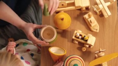 Eller ve öğrenci ahşap eko oyuncaklar masası kullanıyor. Pedagoji, takım çalışması Üst görünüm