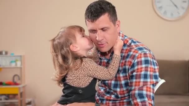 Daughter makes a kiss to dad on the cheek. Good family relations. — Stock Video