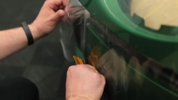 Mechanika kéz tartja védő vinil réteg festék autó modul. — Stock videók