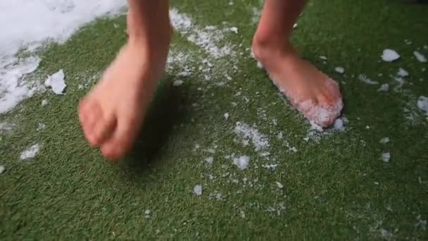 Los pies desnudos golpean hierba verde nieve. Relajación después de caminar descalzo en la nieve — Vídeos de Stock