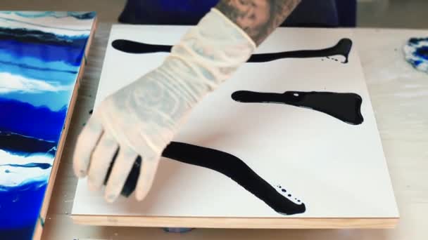 Художник ручной перчатки льет краску на белую поверхность. Семинар художественной практики. — стоковое видео