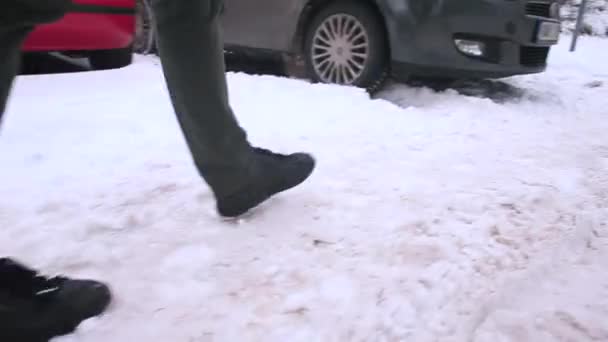 Voetgangers in een besneeuwde straat. Hij stapt in de sneeuw.. — Stockvideo