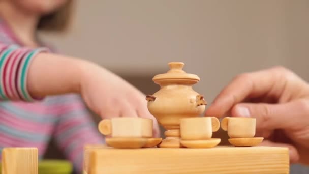 Pequeño servicio de madera en la mesa. Las manos tocan objetos eco juguetes. Tazas y samovar. — Vídeos de Stock