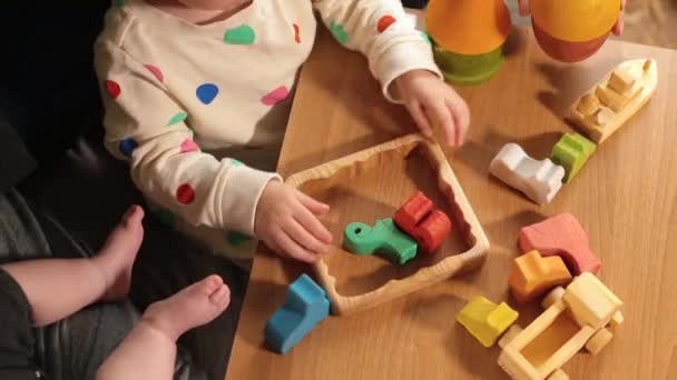 Childs manos poner objetos en la mesa, rompecabezas. Enseñando la lógica del niño. — Vídeo de stock