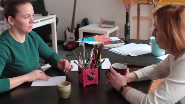 La studentessa si prepara a lavorare come insegnante. Due donne sedute a tavola. — Video Stock
