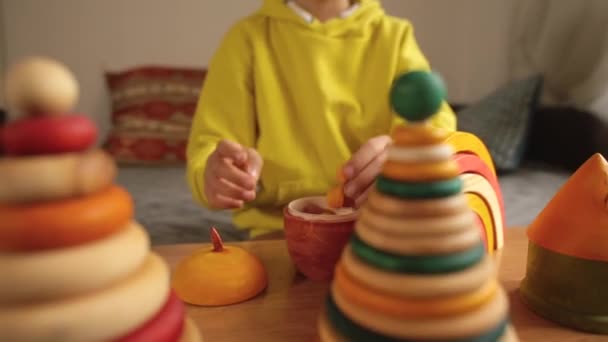 Mãos de criança dobrar bolotas de brinquedo de madeira. Habilidades motoras finas na formação em educação. — Vídeo de Stock