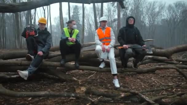 Manager mit Arbeitern sitzt Baum nach der Arbeit. Sie reden. Er hält eine Axt in der Hand — Stockvideo