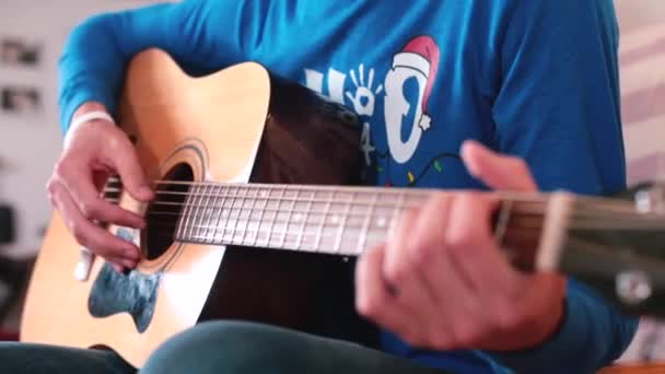 Guy faz blog guitar Movimento ao longo de cordas, gestos mostrando assinantes Olá — Vídeo de Stock