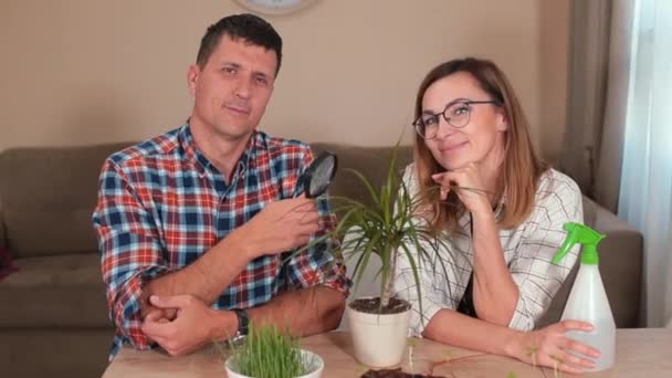 Mann und Frau posieren Tisch Mann hält Lupe, eine Frau Brille — Stockvideo