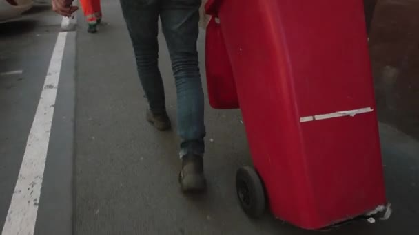 Рух ноги чоловіка, червоний смітник. Збирання відходів у місті — стокове відео