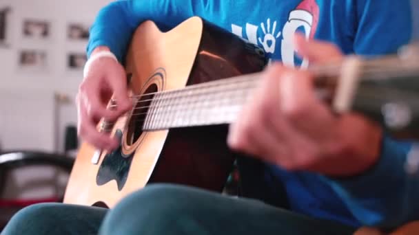 O homem toca guitarra. Dedos a bater cordas. Fazendo música em seu tempo livre — Vídeo de Stock