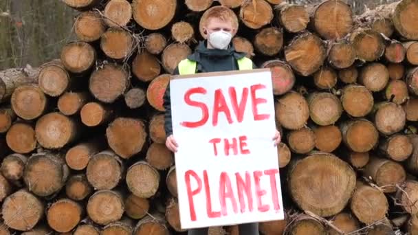 Плакат Врятуйте планету в руках молодого чоловіка в масці на обличчі . — стокове відео