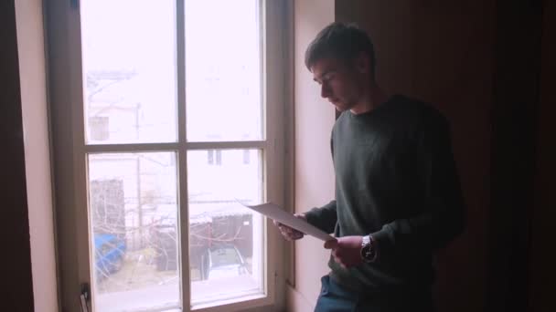 Orang itu memeriksa dokumen-dokumen dekat jendela. Fokus dari penalaran Perhatian. — Stok Video