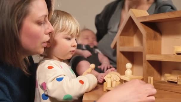 Çocuklu anne tahta oyuncaklarla oynuyor. Rakamları elleriyle yerleştiriyorlar.. — Stok video