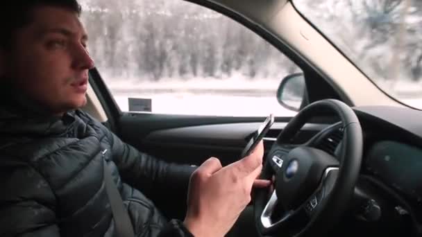 El hombre utiliza el teléfono móvil coche de conducción a mano combina la navegación de control del vehículo — Vídeo de stock