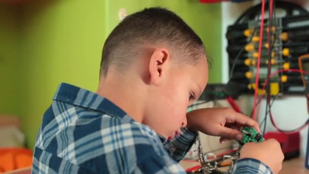 Adolescente hace reparaciones mesa de coche de juguete activa joystick ruedas de movimiento. — Vídeos de Stock
