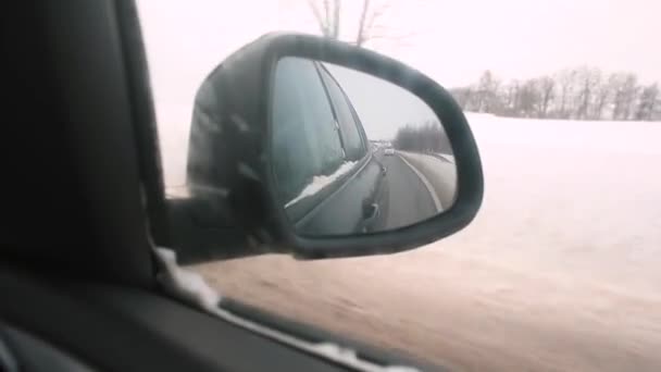 Espejo de coche en movimiento en invierno. Control de la situación de conducción desde el coche trasero. — Vídeo de stock