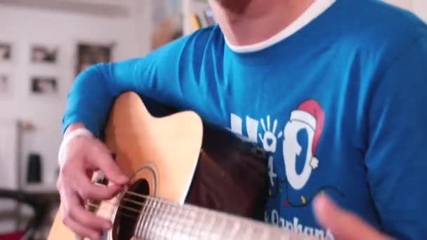 Cheerful guy plays the guitar, sings his favorite melody, sings along. — Stock Video