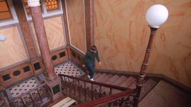 L'homme monte les escaliers dans la maison. Il monte en haut. Déplacer une personne entre les étages. — Video