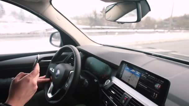 Sürücü araba sürerken telefonu elinde kullanır. Yüksek hızda yol alıyoruz. — Stok video
