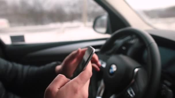 Man mão usa telefone na mão durante a condução do carro. Comunicação durante a condução rodoviária — Vídeo de Stock