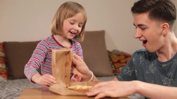 Niespodzianka z nową zabawką Otwieranie prezent na stole młody tata otwiera niespodziewane ręce — Wideo stockowe