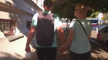 Sırt çantası sırtında iki erkek ve bir kadın şehirde dolaşıyor..